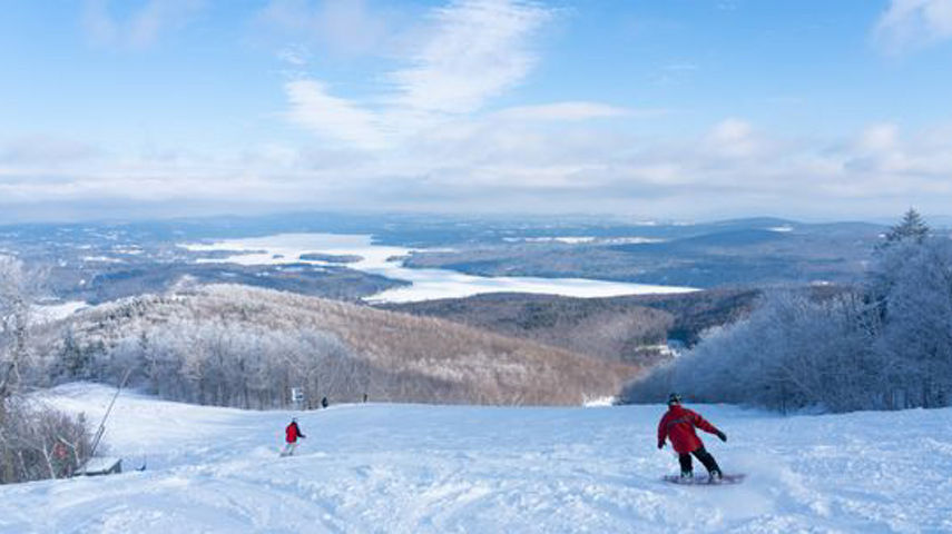 Snowboarder Hitting a Run at Mount Sunapee during a Bluebird Day