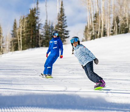 Older children snowboarding with an instructor (ATP)