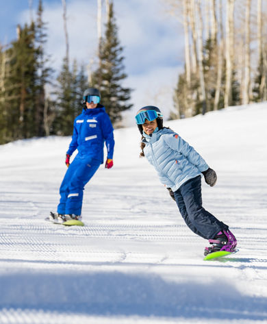 Older children snowboarding with an instructor (ATP)