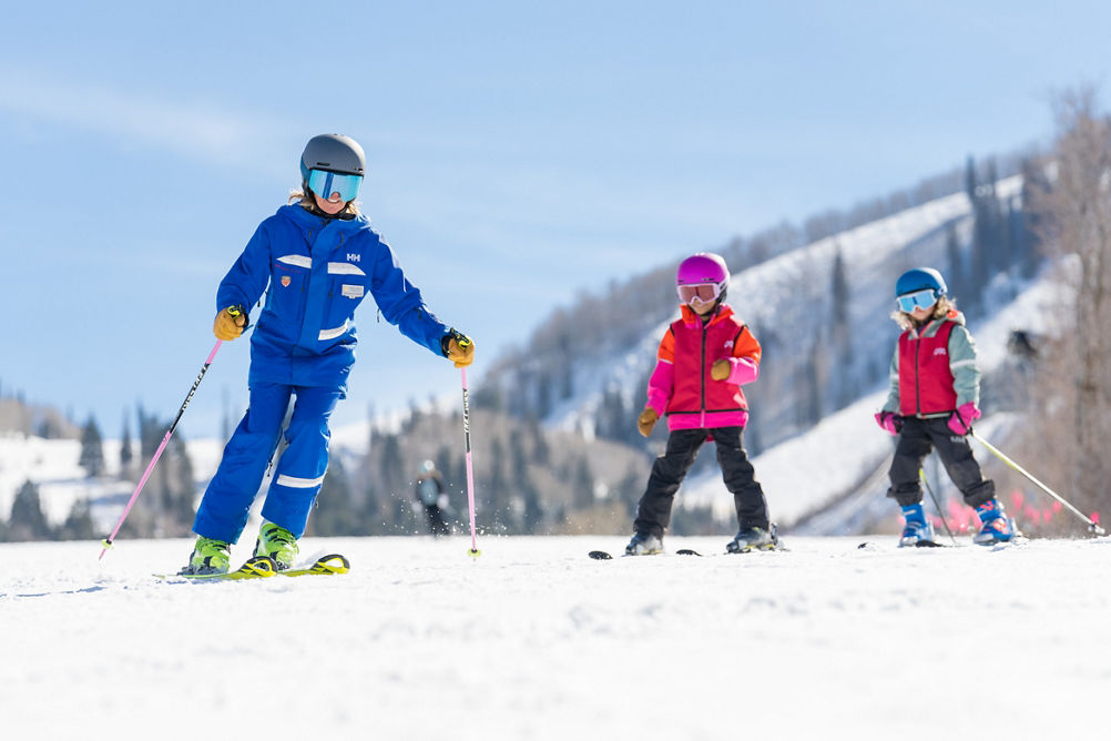 Young children skiing with an instructor