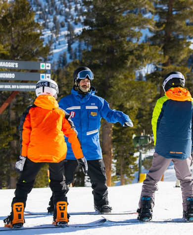 Older children snowboarding with an instructor
