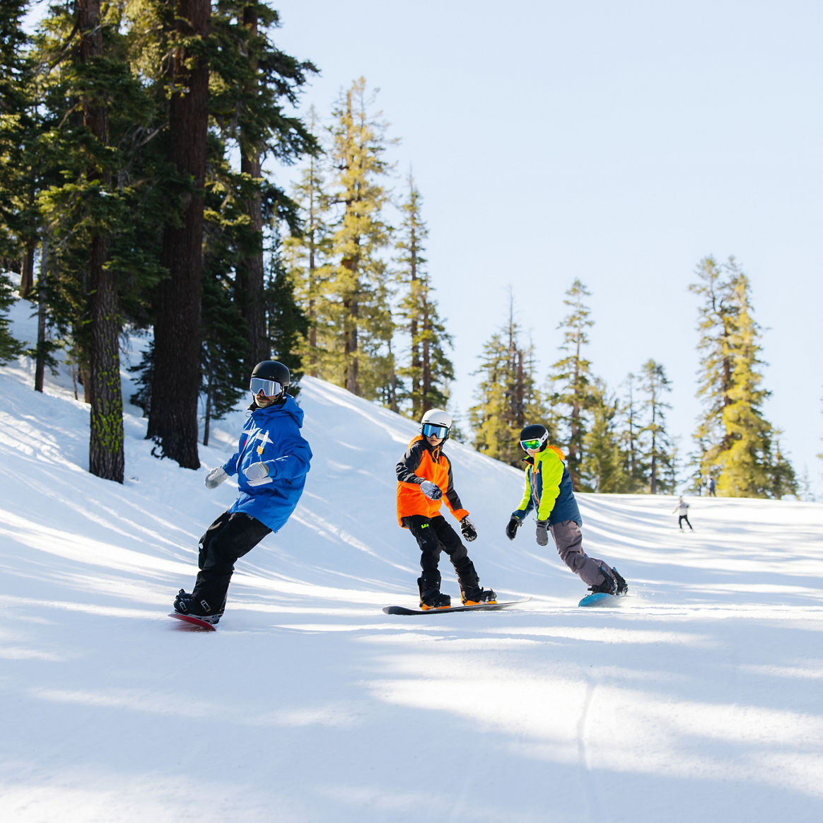 Older children snowboarding with an instructor