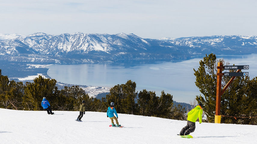 Adults snowboarding with an instructor