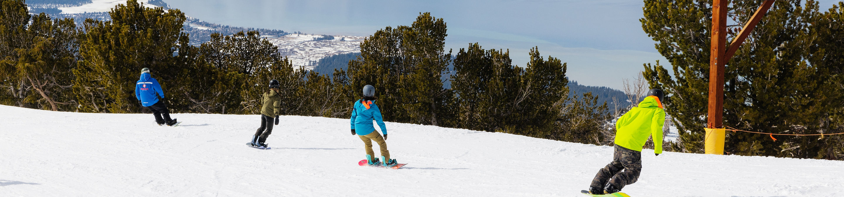 Adults snowboarding with an instructor