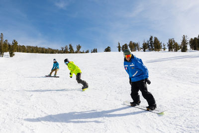 Adults snowboarding with an instructor