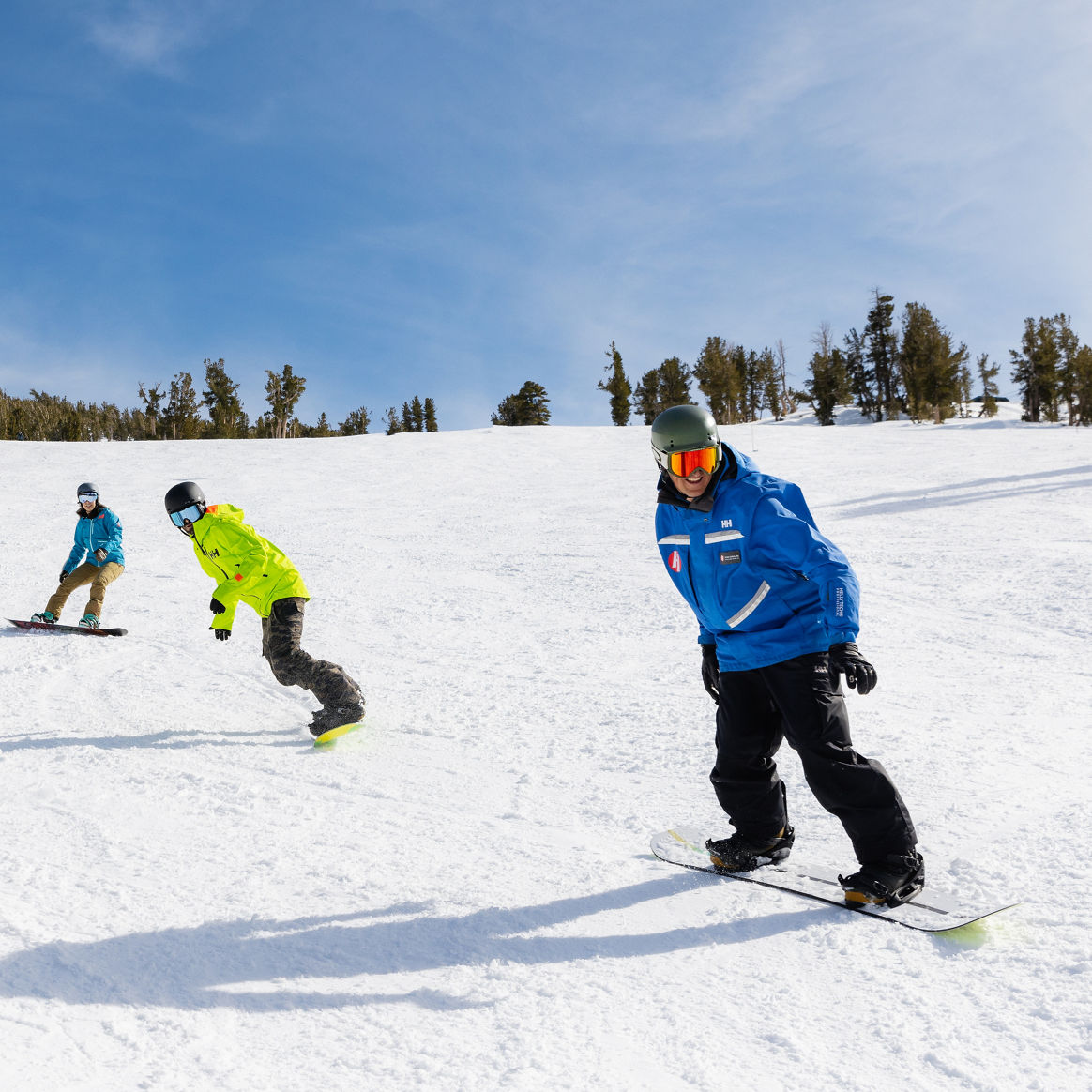 Adults snowboarding with an instructor