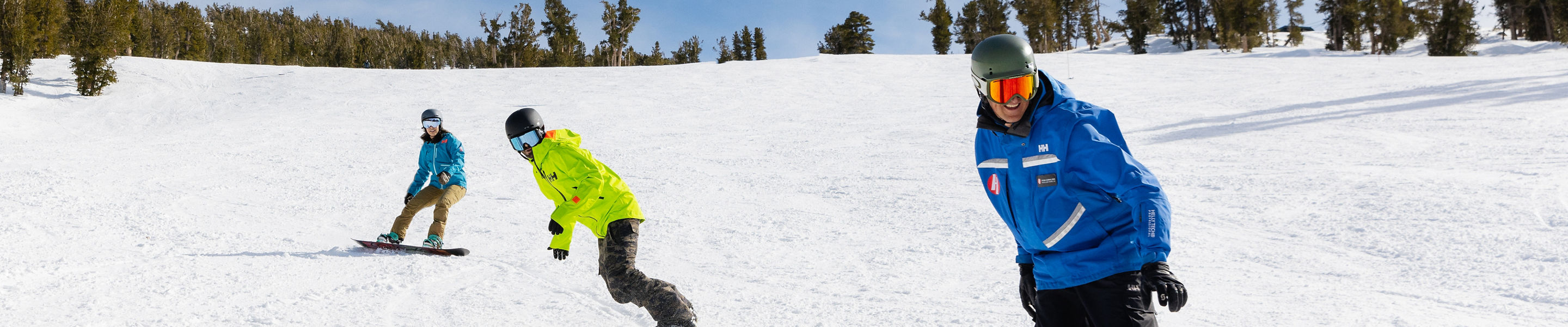 Adults snowboarding with an instructor