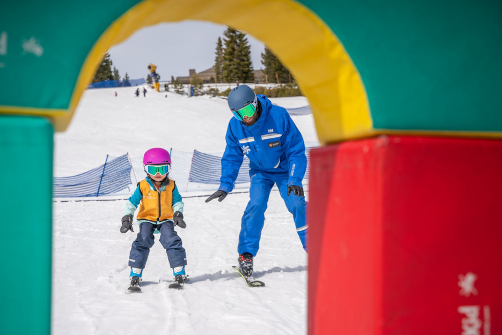 Young children skiing with an instructor