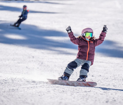 Older children snowboarding with an instructor