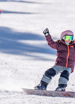 Older children snowboarding with an instructor