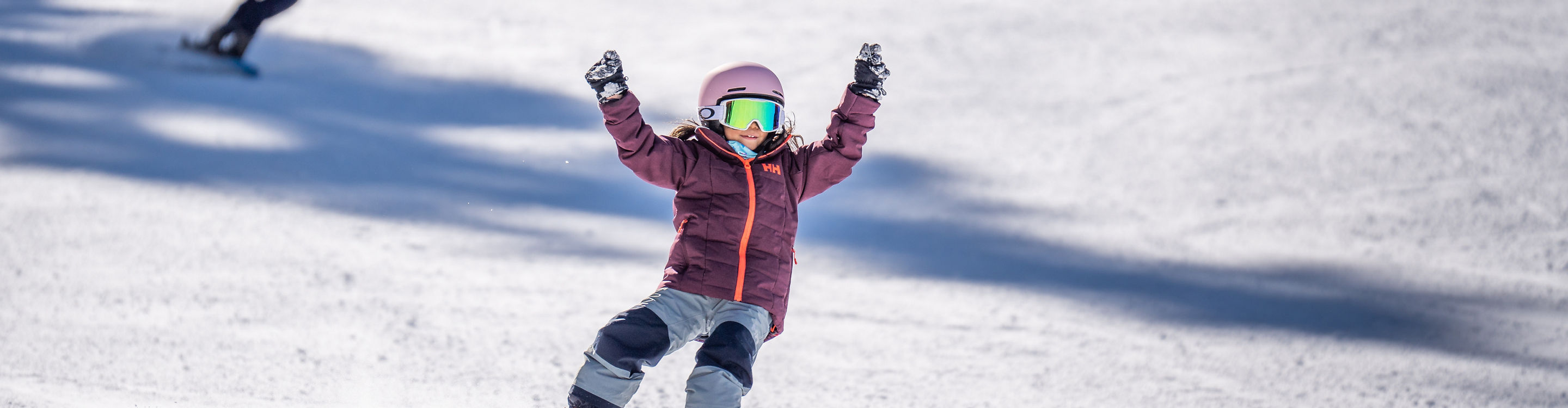 Older children snowboarding with an instructor