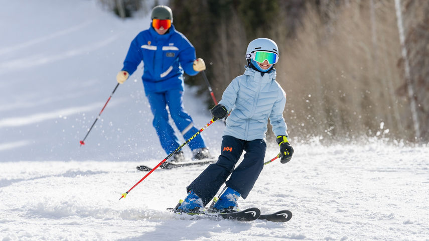 Older children skiing with an instructor (ATP)