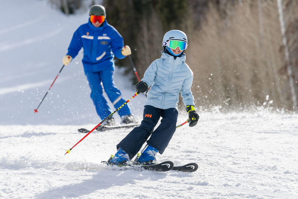 Older children skiing with an instructor (ATP)