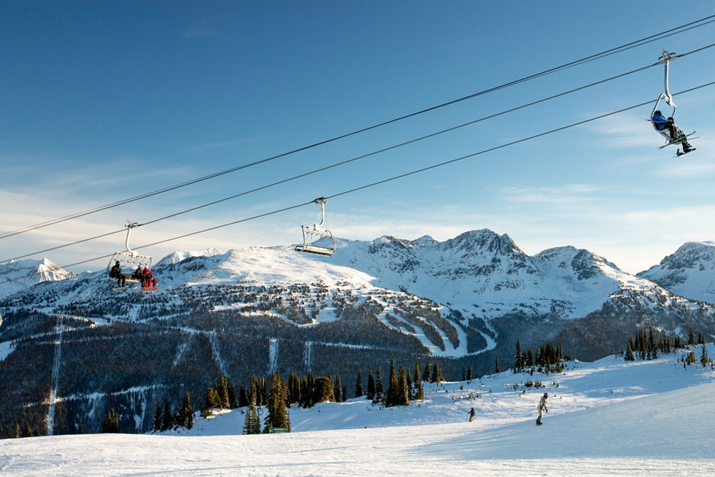 A snowboarder rides on a sunny day in Ego Bowl on Whistler Mountain