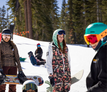 Female snowboarder friends laugh during Rockstar Women's Only Weekend at Northstar