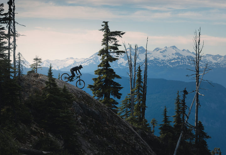 Mountain Biker descending massive rock roll in the bike park