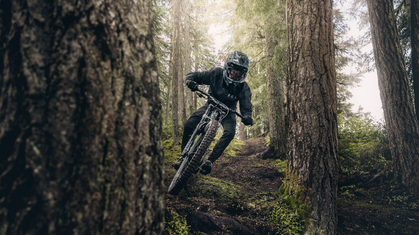Mountain biker weaving through trees in Creekside