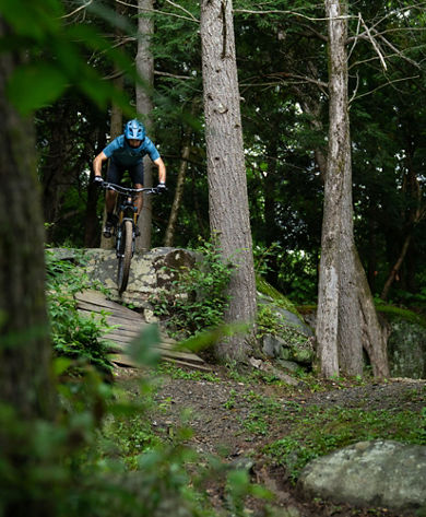 Man Rides Mountain Bike on a Forested Trail in Mount Sunapee