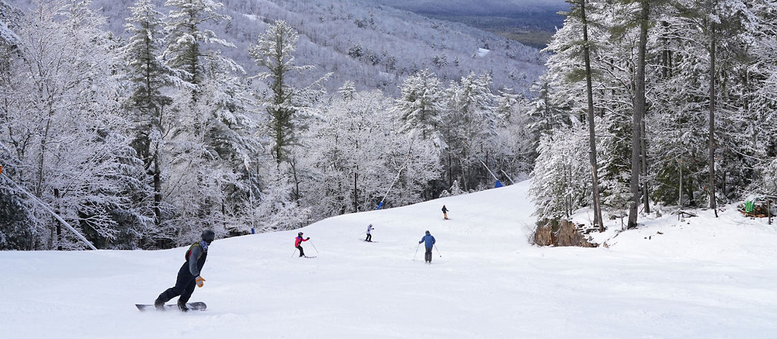 Group of Skiers and Snowboarders Ride in Hazy Winter Weather at Attitash