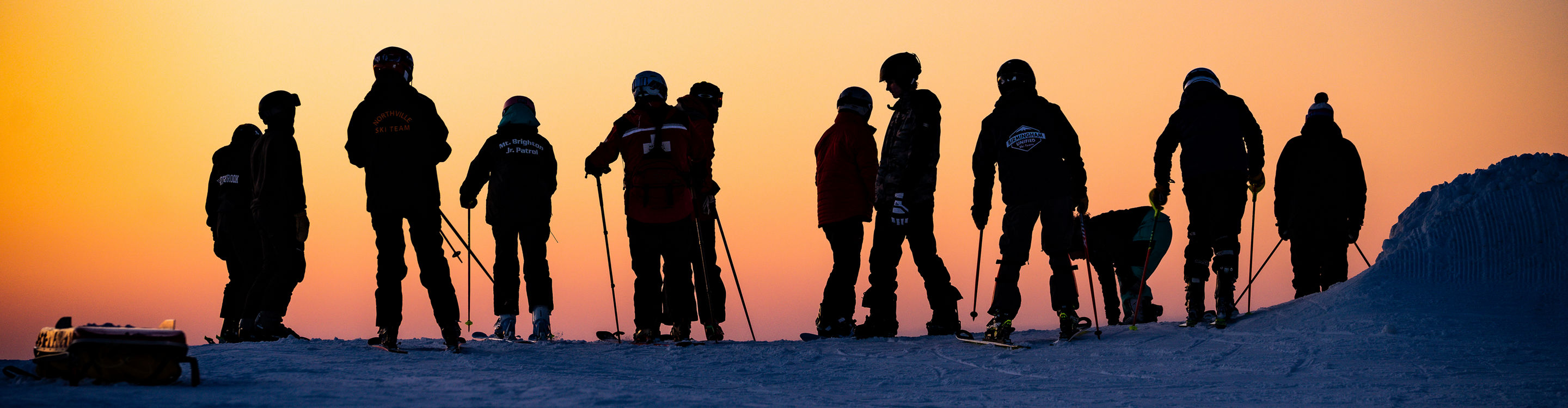Silhouettes of Skiers Overlooking Sunset at Mt. Brighton