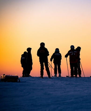 Silhouettes of Skiers Overlooking Sunset at Mt. Brighton