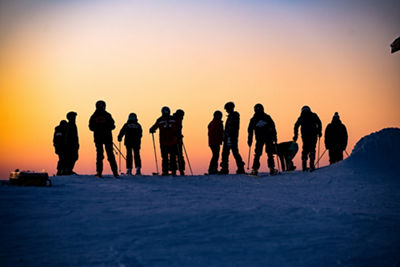 Silhouettes of Skiers Overlooking Sunset at Mt. Brighton