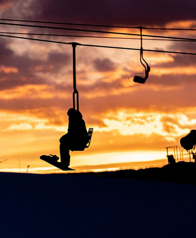 Scenic Silhouette of Snowboarder on Chairlift During Sunset at Boston Mills Brandywine