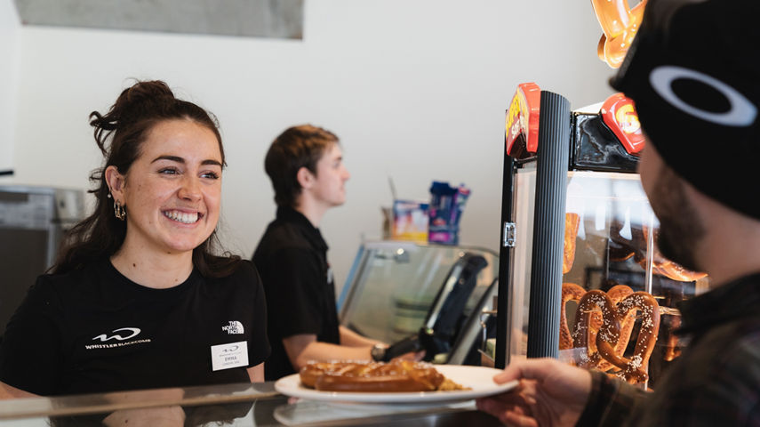 Employee Smiles at Customer at Glacier Creek Lodge at Whistler Blackcomb