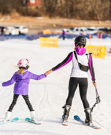 Mother and Daughter Hold Hands Skiing at Alpine Valley