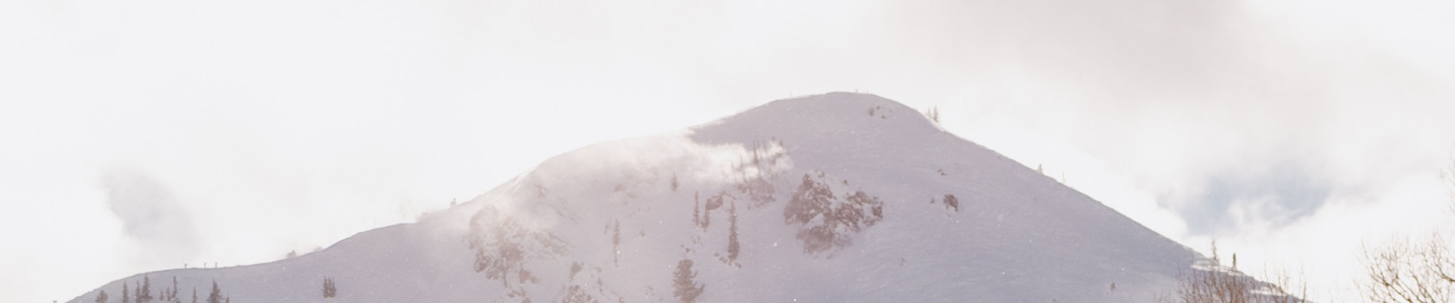 Snowboarder in Light Green Jacket Riding Down the Mountain at Park City