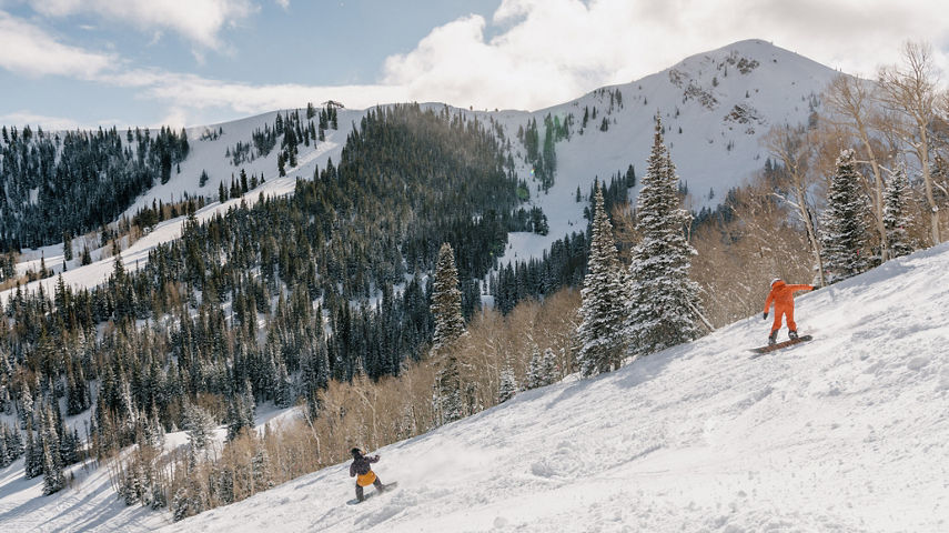 Two Snowboarders Ride Down Trail at Park City