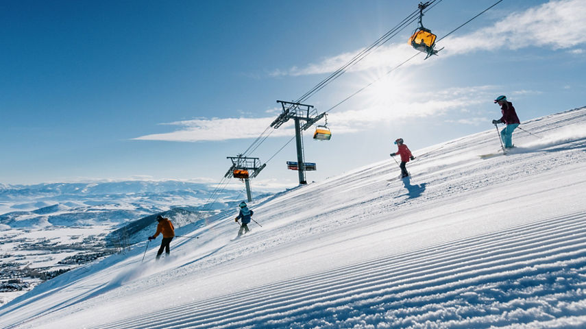 Adult and Young Child Skiers on a Trail Beneath the Chairlift at Park City