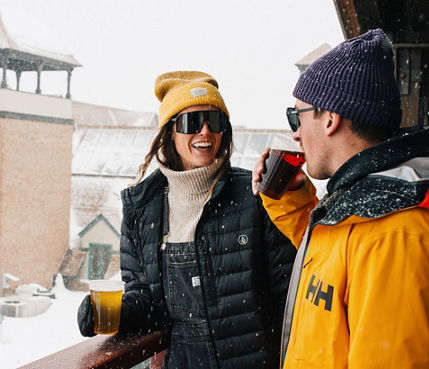 Woman and Man Enjoy Drinking a Beer During Apres at Park City