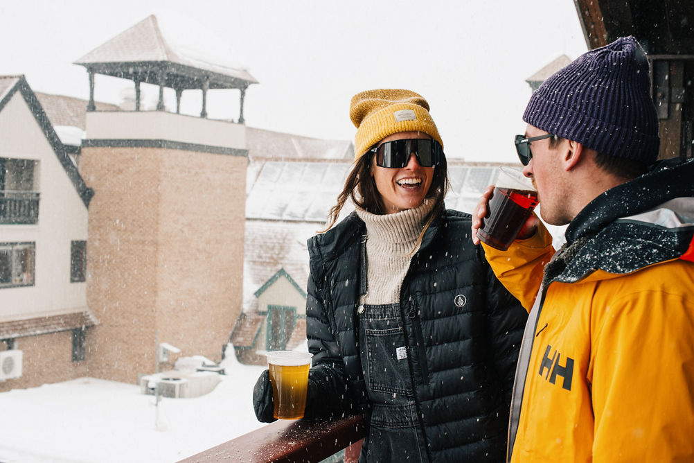 Woman and Man Enjoy Drinking a Beer During Apres at Park City
