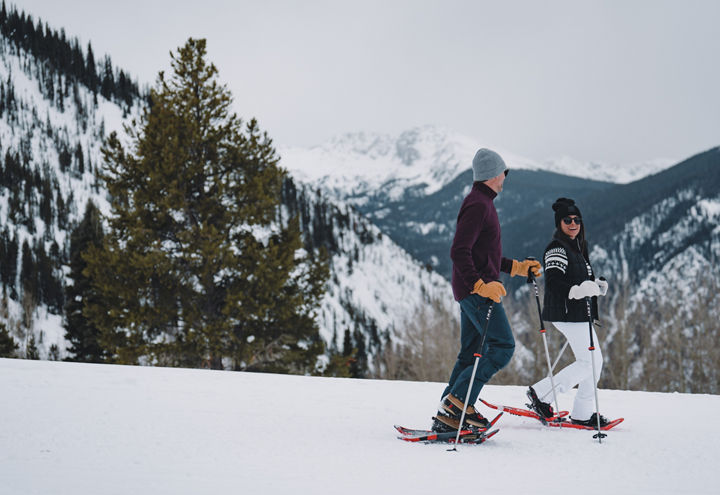 Couple Snowshoing with Scenic View in Background at Beaver Creek