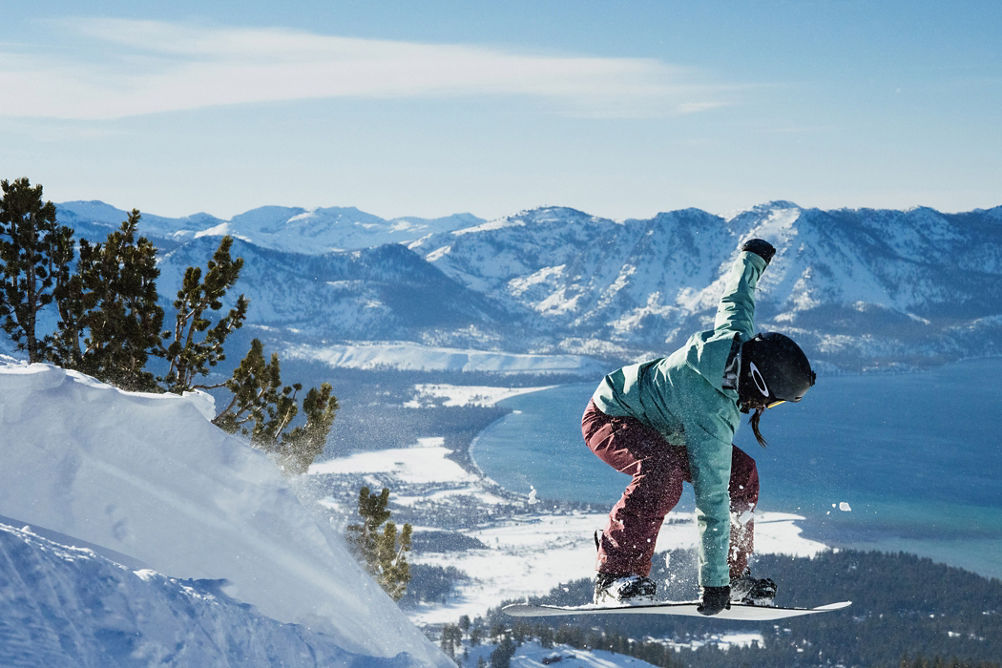 Snowboarder Leaps Off Advanced Terrain Ledge at Heavenly with Scenic View of Lake Tahoe in the Background