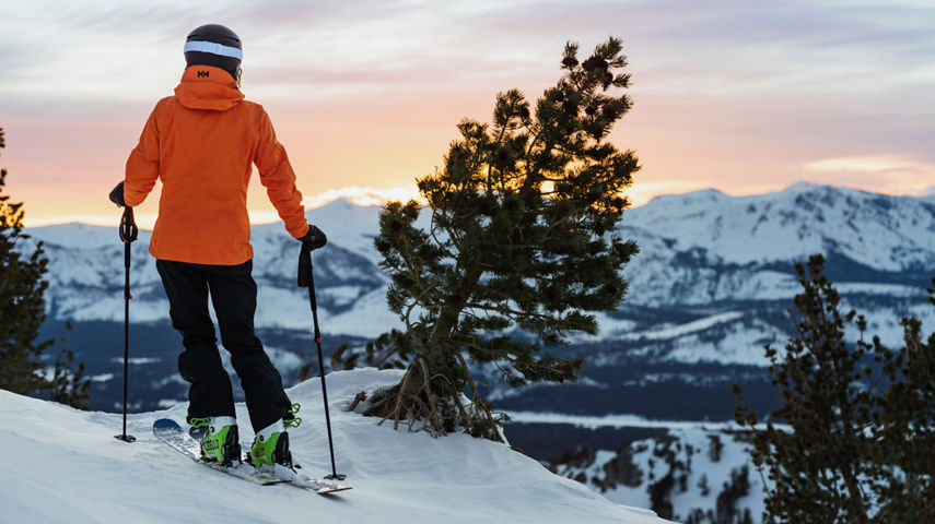 Skier Stands at the Top of a Trail Looking at the Sunrise from Heavenly