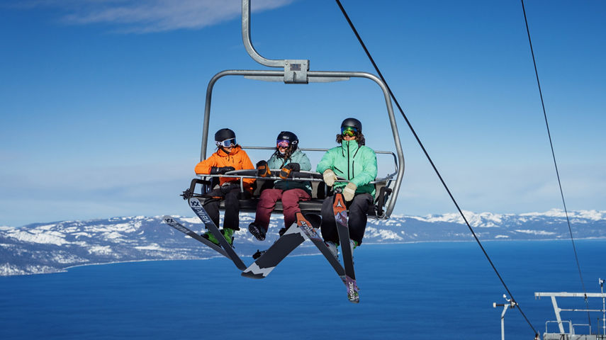 Friends Right a 3-Person Chairlift at Heavenly with a Scenic View of Lake Tahoe in the Background