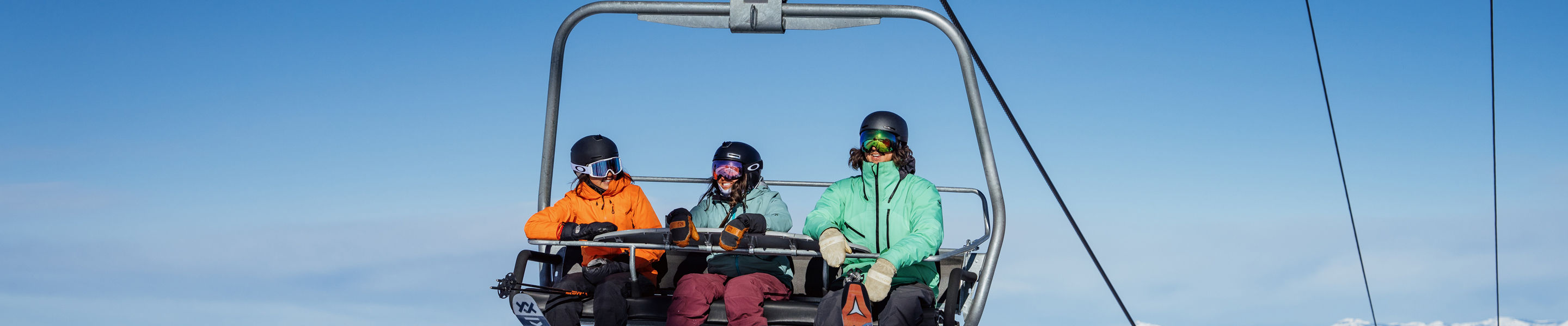 Friends Right a 3-Person Chairlift at Heavenly with a Scenic View of Lake Tahoe in the Background