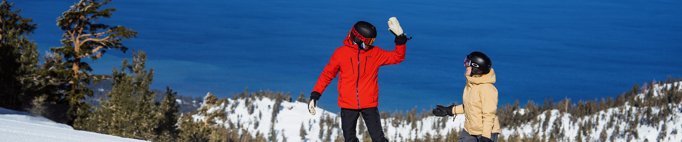Snowboarders Prepare to High Five at the Top of a Run at Heavenly with a Scenic View of Lake Tahoe in the Background