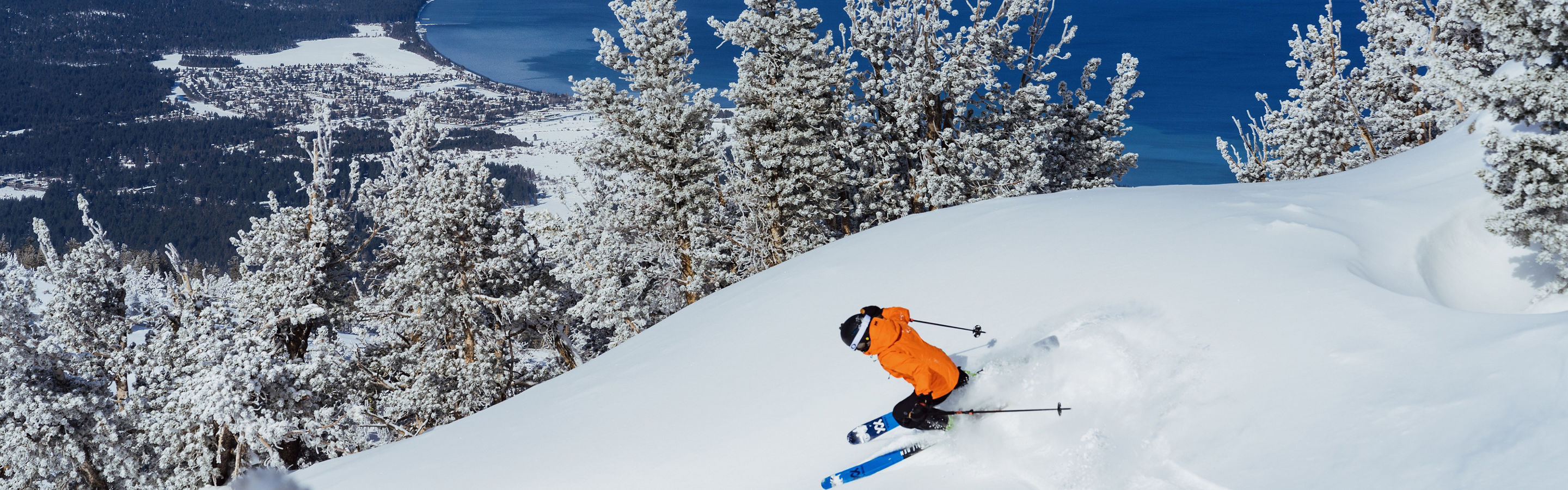 Skier Shreds Through Fresh Powder on a Bluebird Day at Heavenly with Lake Tahoe in the Background