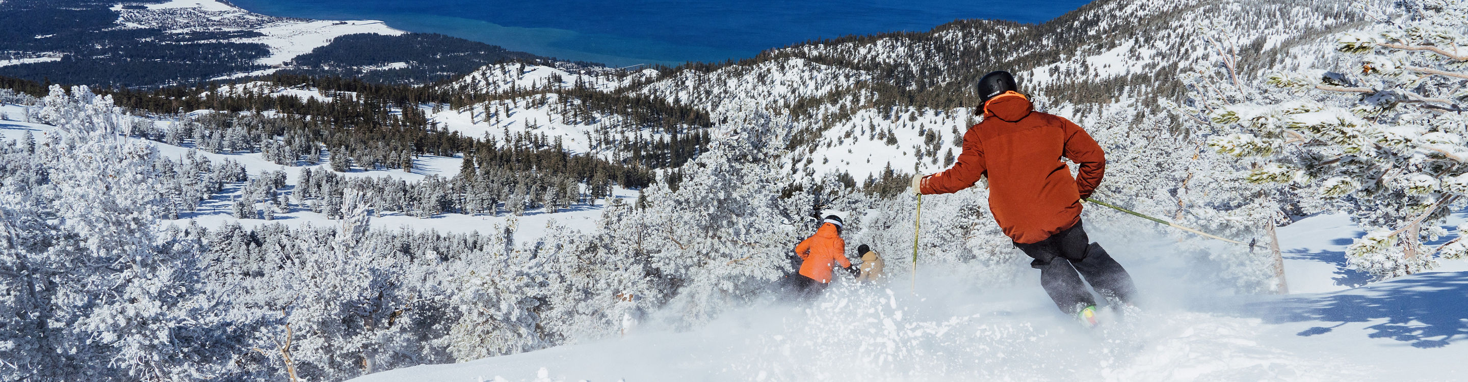 Skiers Follow Each Other Through Fresh Powder at Heavenly with Lake Tahoe in the Background