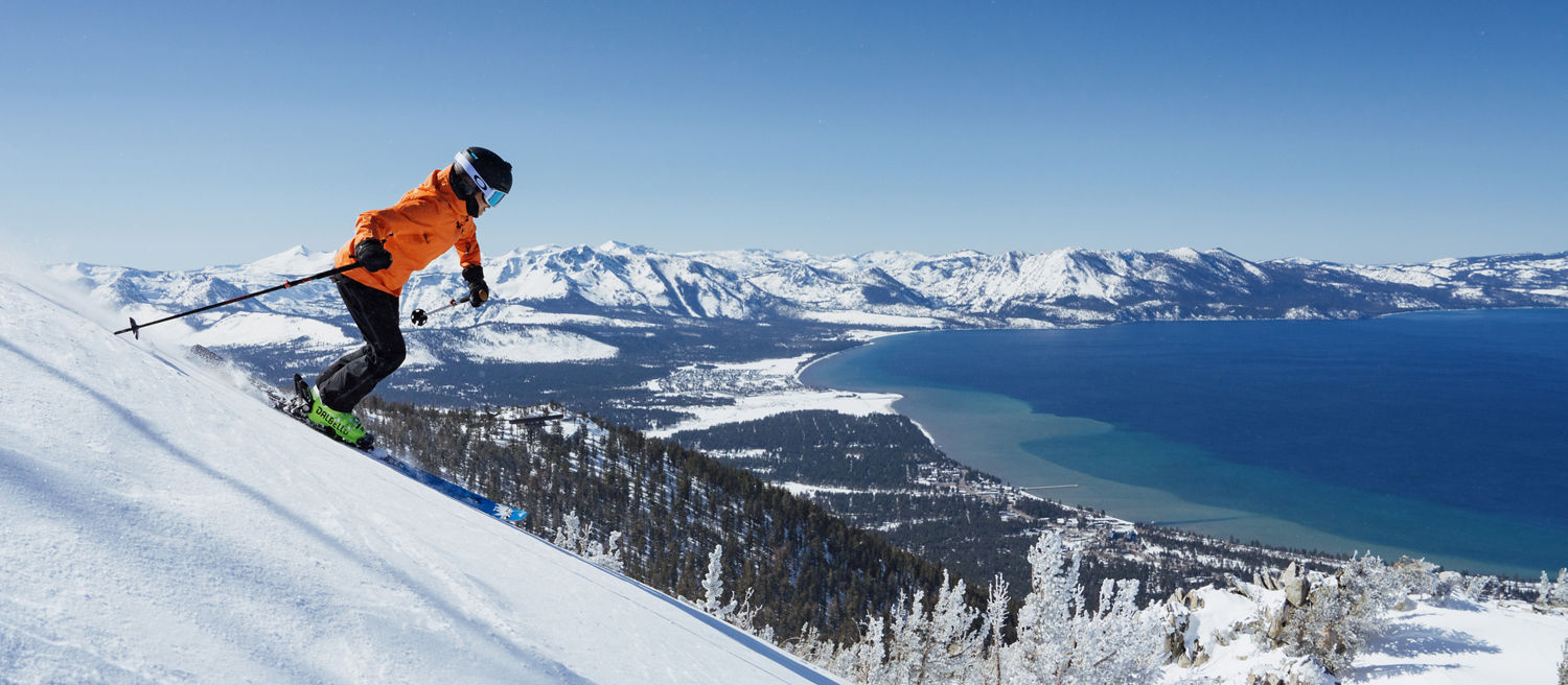 Skier Shreds Through Fresh Powder on a Bluebird Day at Heavenly with Lake Tahoe in the Background