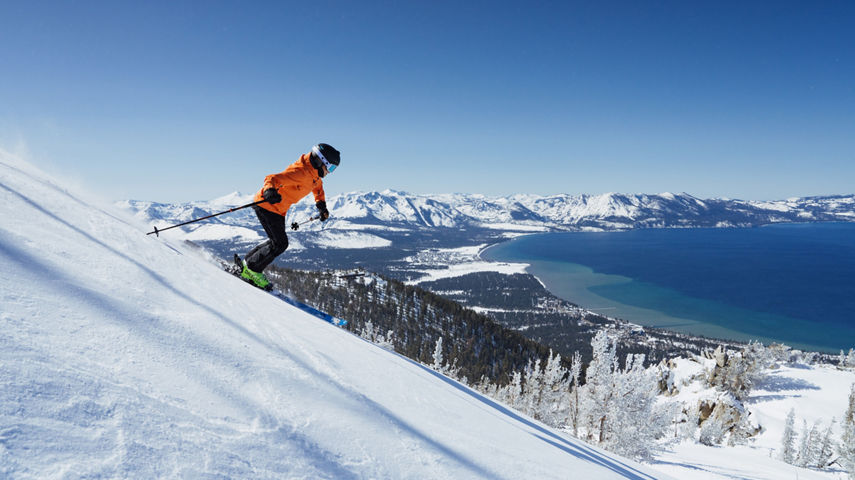 Skier Shreds Through Fresh Powder on a Bluebird Day at Heavenly with Lake Tahoe in the Background