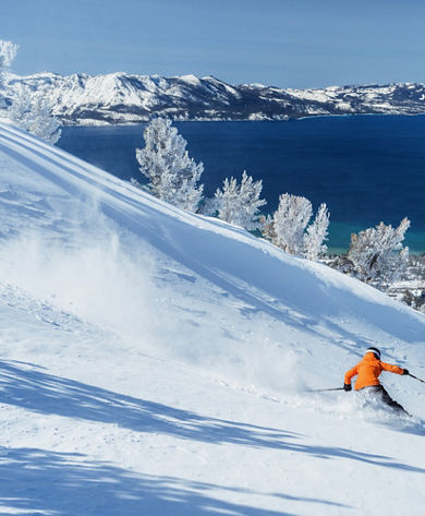 Skier Shreds Through Fresh Powder on a Bluebird Day at Heavenly with Lake Tahoe in the Background