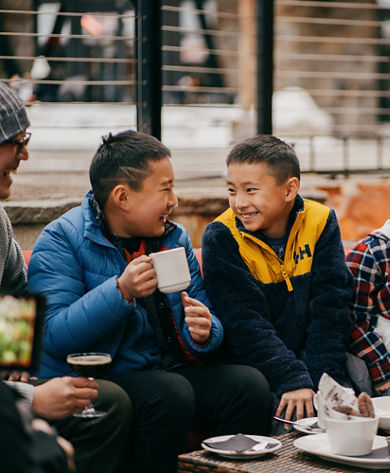 Family Enjoys Hot Cocoa and Snacks Near a Firepit at Northstar