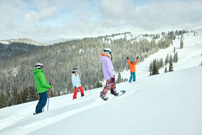 Group of Snowboarders and a Skier Enjoying Riding Down Fresh Snow on a Trail at Keystone