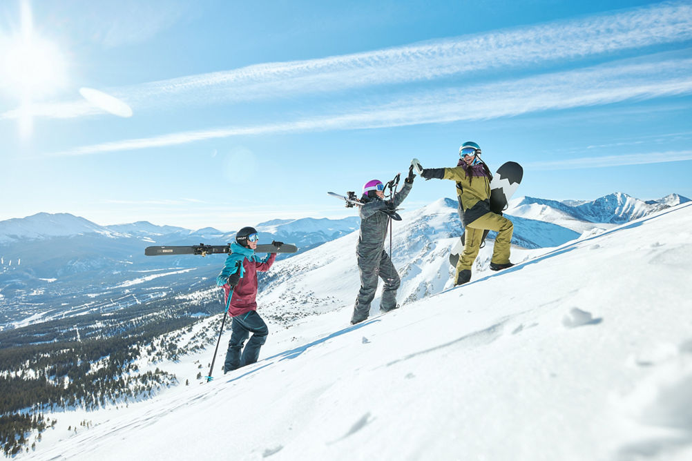 Skiers and Snowboarder Hiking Up Ski Trail with Gear at Breckenridge