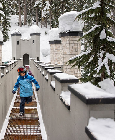 Two Children Run Through a Wintery Children's Fort Structure at Whistler Blackcomb