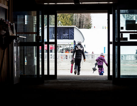 Resort Guests Carry Walk Towards Gondola (no logo) with Ski Equipment in Hand After Leaving Epic Mountain Rentals at Whistler Blackcomb